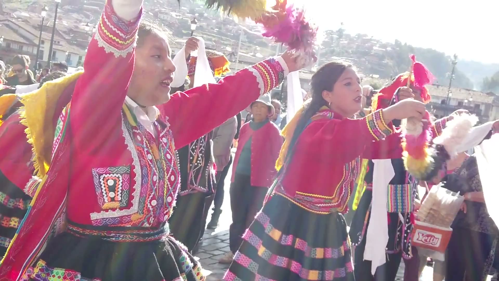 Danzantes con trajes tradicionales en una celebración real en las calles de Cusco, filmada por Janeth Charris.